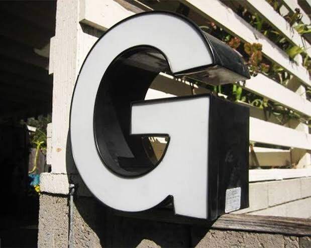 Large white acrylic 3D letter with black returns installed outdoors, made by ALFA Signage