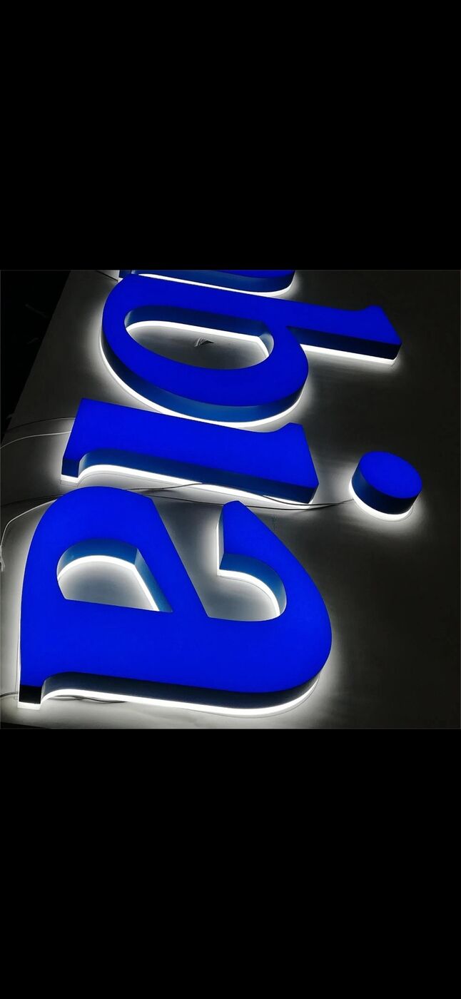 Blue LED-lit acrylic letter sign glowing against a dark wall, made by ALFA Signage