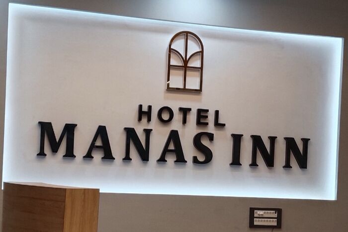Backlit hotel reception sign with 3D letters above a curved reception desk, made by ALFA Signage